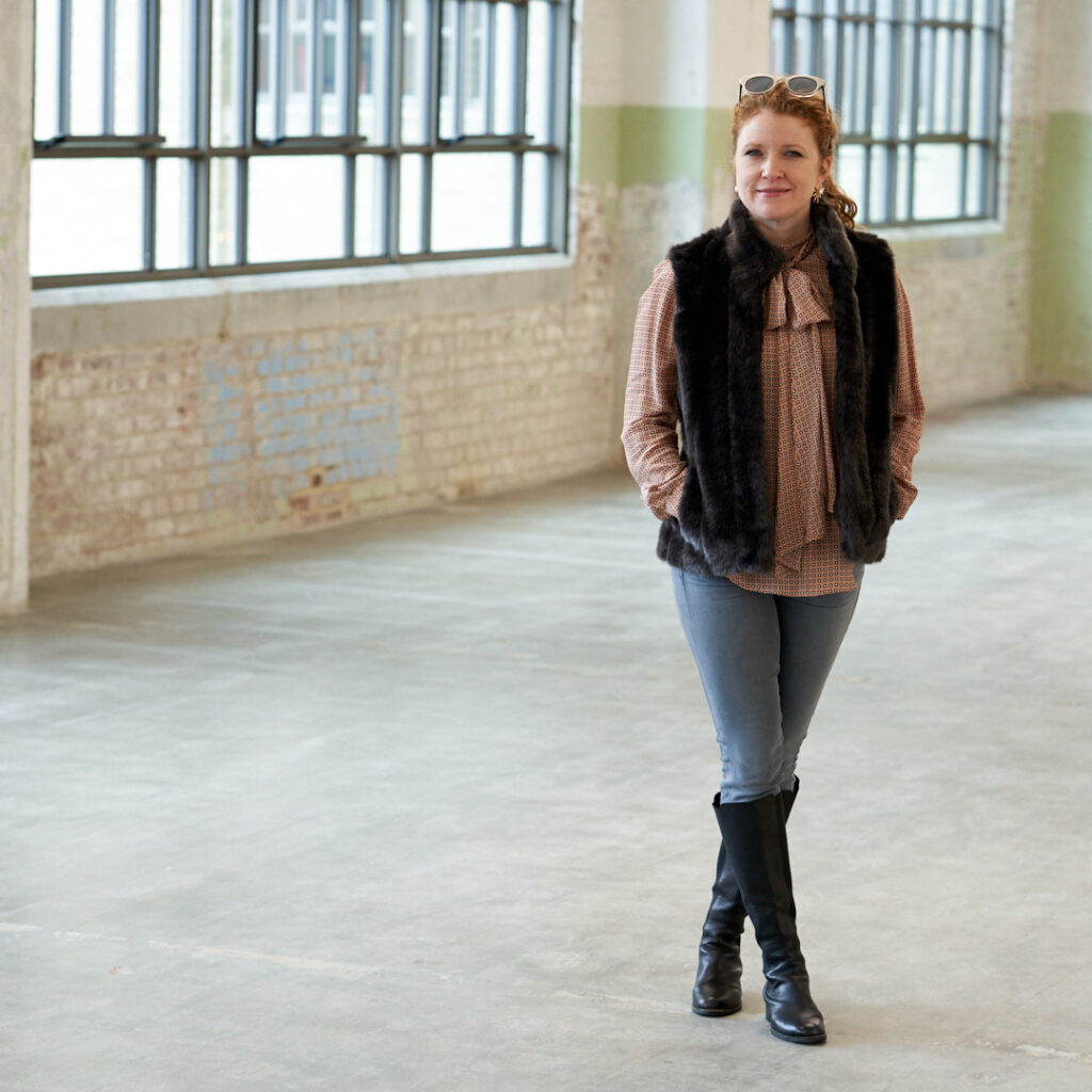 Jamie in Faux Fur Vest and Zara Blouse, Gray Jeans and knee high black boots.