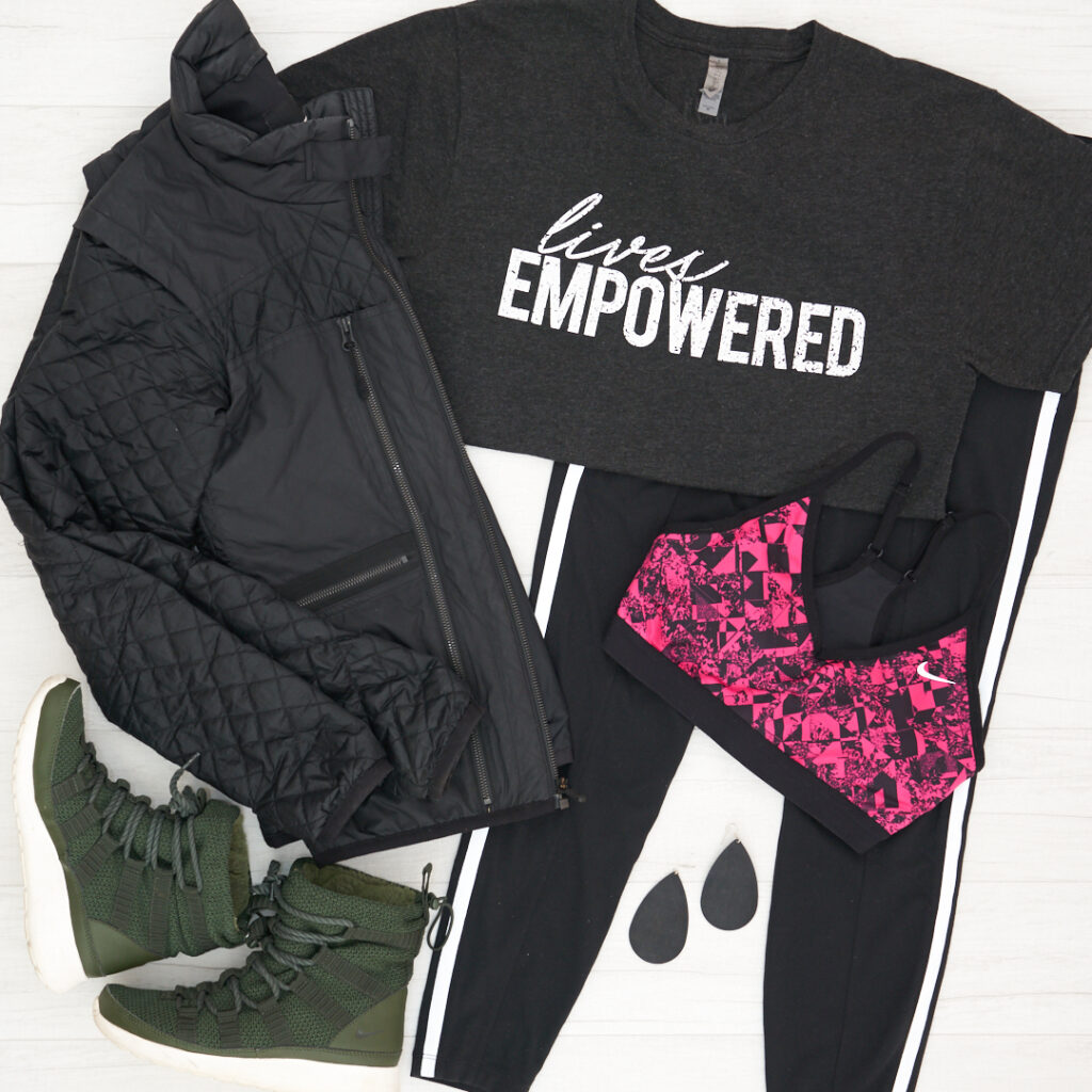 Lives Empowered GiveGood Co t-shirt with Athleta 7/8 Metro Tights and a pink and black Nike bra, Nike fleece booties and quilted jacket and Nickel and Suede black cork earrings.