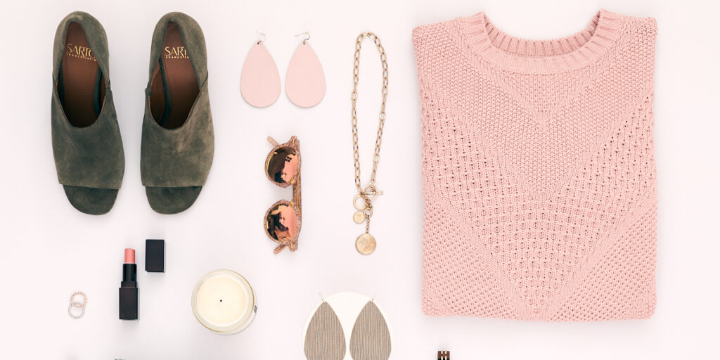 Flat Lay of Sweater, Shoes, Necklace, Candle and Sunglasses