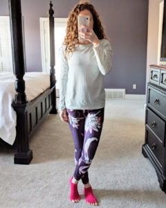 Mirror shot of Jamie in floral powervita leggings and nike top with pink toesox