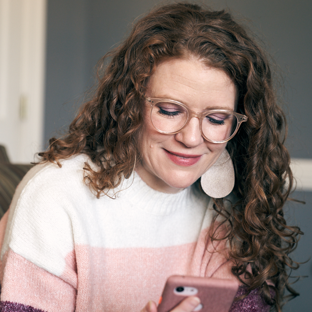 Photo of me looking down at my phone with my glasses from Liingo Eyewear