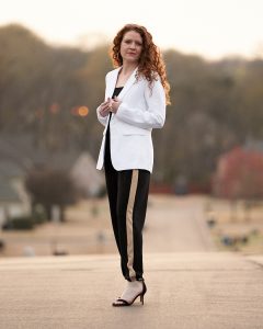 Styled jumpsuit with white blazer and black high heels and gold hoop earrings