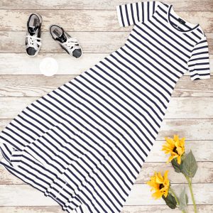 Flat lay of blue and white maxi dress from J Crew with golden goose sneakers, gold hoops and sunflowers