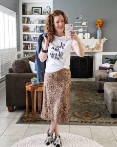A Mirrorshot of me wearing the spotted slip on skirt with a graphic tee and a denim jacket with golden goose sneakers.