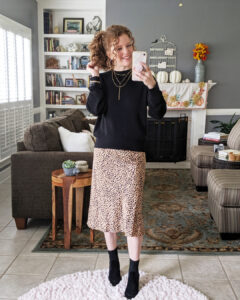 Mirror shot of me wearing the spotted slip on skirt with a plain black hi-low sweater and dressy black booties.