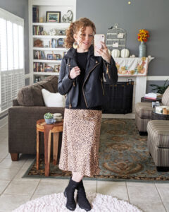A mirrorshot of me wearing the slip on midi skirt and a black top with a black moto jacket over it. Paired it with black booties.