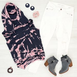 Flat lay of tie dye sweatshirt with white jeans, booties and fun statement earrings